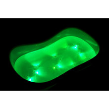 Glowing green bath bomb in dark water