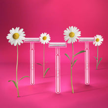Set of pink disposable razors with white daisy flowers attached