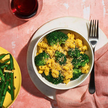 Vegan cheddar-style mac & cheese in a bowl topped with broccoli florets