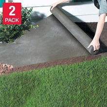 Gray landscaping fabric sheet covering soil under shrubs and lawn grass