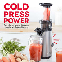 Compact cold press power juicer with glass cup filled with orange juice.