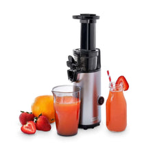 Compact cold press power juicer with black hopper and spout, with juice cup and bottle.