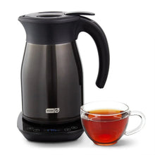 Black insulated electric kettle with handle and spout, with a glass cup of tea