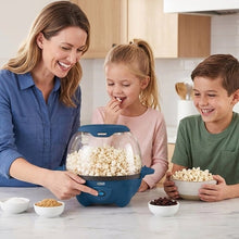 Family using blue countertop popcorn maker with clear lid and popped corn