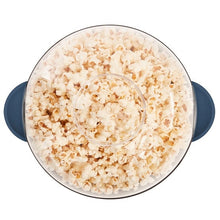 Top view of blue popcorn maker lid with popped popcorn filling the pot