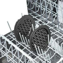 Waffle maker plates in dishwasher rack, two round inserts standing upright.
