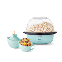 Light teal electric popcorn maker with clear stirring lid and serving bowls