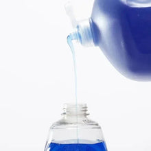 Blue dish soap stream pouring from bottle with clear pump nozzle