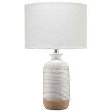 Table lamp with white drum shade and ribbed ceramic body with metal neck