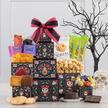 Four-tier candy treat tower with decorated boxes, red-black bow, and assorted wrapped treats
