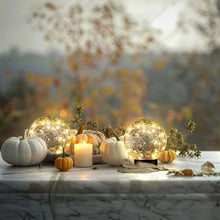 Gold crackle glass LED globe solar lights with warm glow among autumn decor and pumpkins