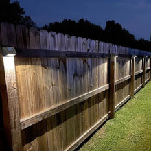Solar downcast deck lights along a fence, dark housings emitting warm light