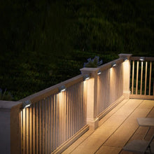 Solar downcast deck lights lining a railing, dark housings with warm glow