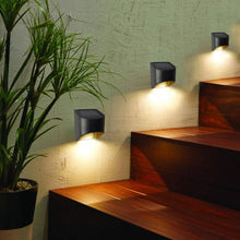 Solar deck downcast lights, dark aluminum housings shining warm light on steps