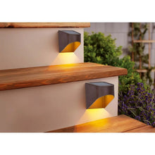 Solar deck lights (pair view), dark aluminum body with amber downcast glow opening