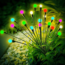 Colorful solar firefly lights glowing with round globe bulbs atop black stakes