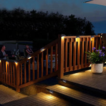 Solar deck and wall lights casting warm white glow along a stair railing