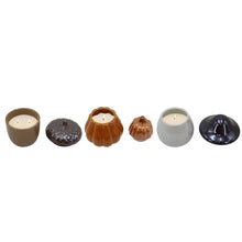 Assorted ceramic candle holders in brown, orange, cream, and dark gray