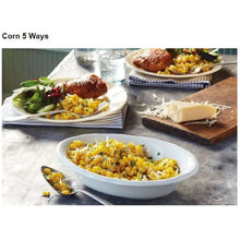 Dinner table with a bowl of whole kernel corn and plated side dishes