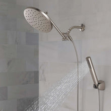Chrome shower head and hand shower with water stream from shower head