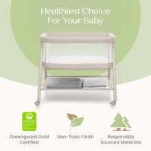 Tan bassinet with mesh panel and padded sleep surface, caster wheels visible