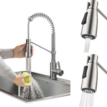 Pull-down faucet spray head dispensing water over sink; stainless finish, single handle