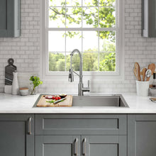 Stainless kitchen faucet centered over sink with pull-down high arc spout