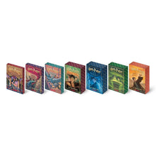 Set of seven Harry Potter paperback books with colorful illustrated covers, books standing