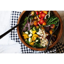 Vegetable salad bowl topped with sliced almond pieces and herbs.