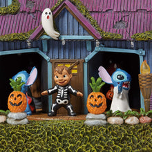 Halloween house display with skeleton costume figure, Stitch, and jack-o'-lanterns.
