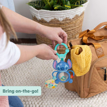 Stitch tummy tumble activity toy clipped to a stroller handle and backpack