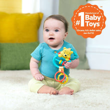 Busy bear activity toy with ring handle and dangling beads, held by a baby on the floor