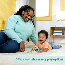 Busy bear activity toy with colorful beads and rattle, on carpet near a smiling baby
