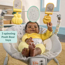 Newborn baby bouncer with gray Pooh-print seat and spinning toy bar
