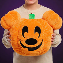Orange Mickey-style pumpkin head plush with black smiling face and green stem, held in hands