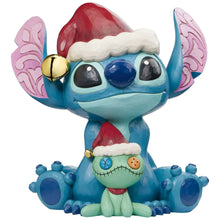 Stitch and Scrump resin statue wearing Santa hat and holding stitched doll figure