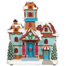 Snowy turquoise house figurine with red windows, wreaths, and front steps