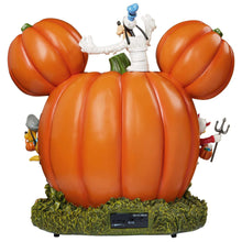 Orange pumpkin-house display with character on top and green grass base