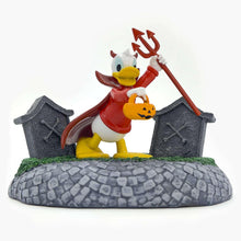 Halloween village decoration with a pumpkin-headed figure, red pitchfork, and gray fence posts