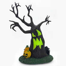 Halloween village decoration with a dark tree base, neon green bat shapes, and a jack-o'-lantern