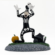 Halloween village decoration with a dancing skeleton figure, black tombstones, green grass, pumpkin