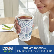 Paper to-go cup with blue geometric print and gray lid, filled with drink