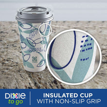 Paper cup with gray lid and teal-and-blue geometric wrap design, lid detail.
