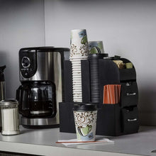 Stacked black hot cup lids on to-go coffee cups at coffee counter.