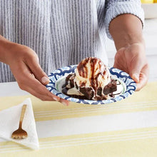 Paper plate with blue patterned rim holding dessert
