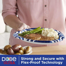 Paper dinner plate with blue rim holding baked potato and side foods, held by person