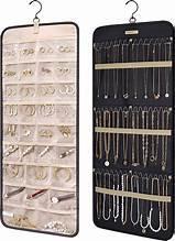 Hanging jewelry storage roll with metal hooks, earring slots, and necklace bars