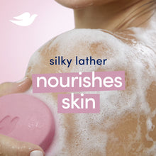 Pink soap bar with Dove emblem partially lathered, with “silky lather” text