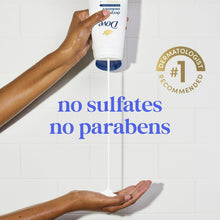 Body wash tube being squeezed into hands over shower tiles