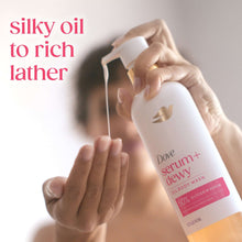Hands holding oil body wash bottle, dispensing silky lather from white pump